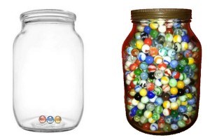 Empty jar of marbles next to a full jar of marbles